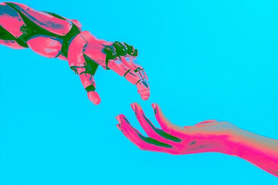robot and human hands reaching toward each other